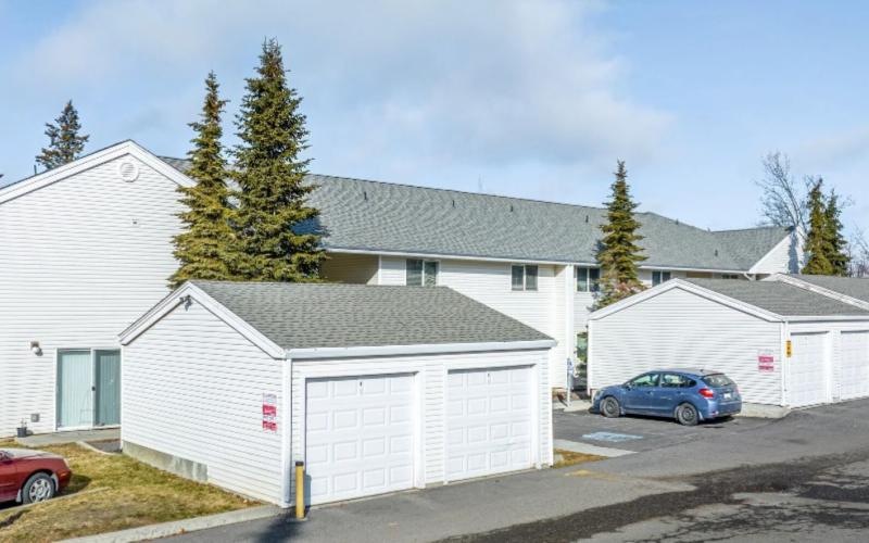 a building with garages and cars parked in front of it