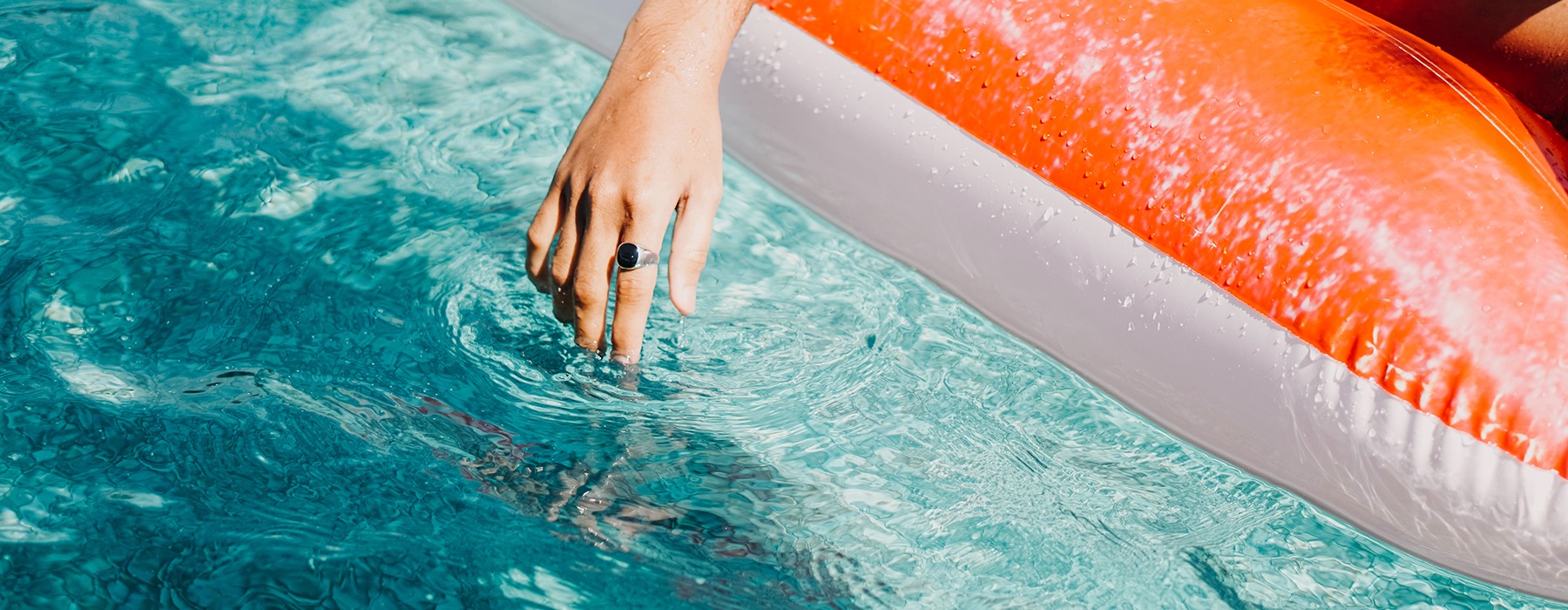 lifestyle image of a woman floating on a device in a pool