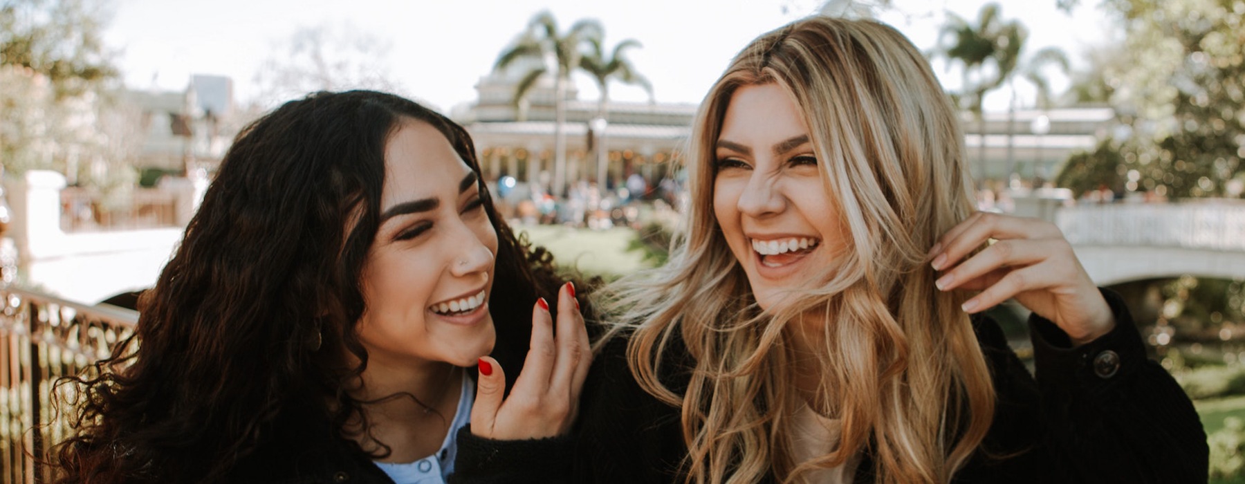 two women laughing outdoors