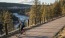 a man riding a bicycle on a bridge over a river